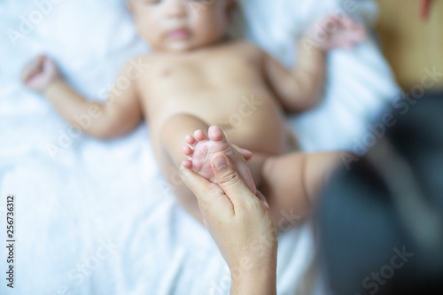 Baby foot massage by mom hand after shower