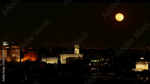 Timelapse Red Moon rises. Rome aerial night view of historical center illuminated, Domes, roofs and monument. Synagogue, Capitol, tower, venice square.