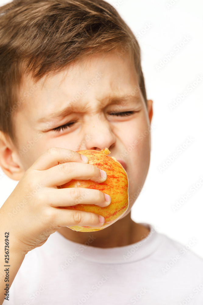 Little boy is eating apple with toothache Little boy is eating apple with toothache