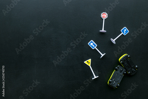 Car insurance concept with car toys on black background top view copyspace