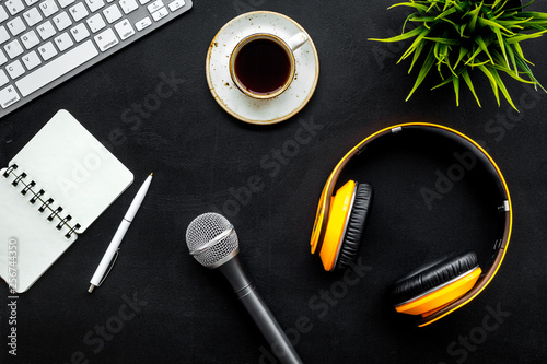 podcast record with keyboard, notebook, microphone and headphones on black background top view space for text