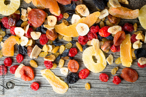 Mix of dried and candied fruit on a wooden background, top view