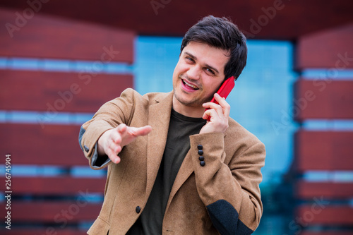 Young businessman talking by phone on the city square