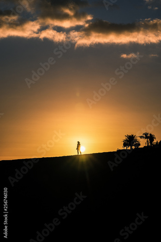 maspalomas dunes, gran canaria, spain, sunset with shadow silhouetes of people in front of sunball