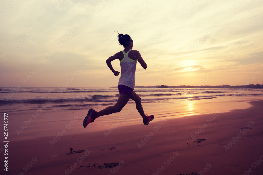 Woman runner running on sunset beach Woman runner running on sunset beach