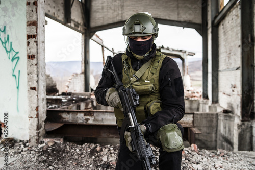 Special forces modern soldier standing in ruined building after the intervention war battle