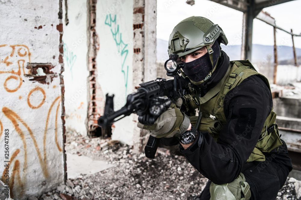 Obraz premium Special forces police soldier in action battle ruined building aiming riffle