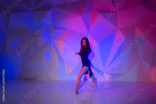 Foto Woman dancing on the background of a beautiful multicolored wall