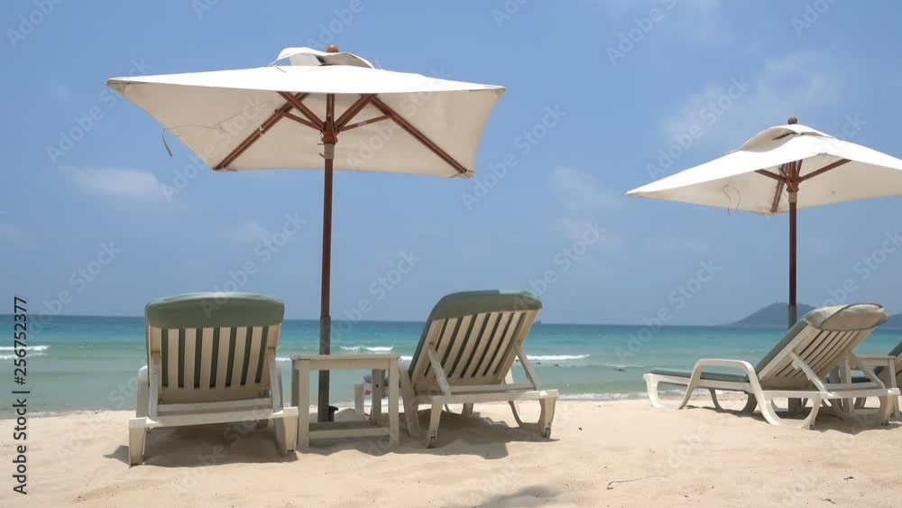 White Beach Beds on Tropical Sandy Beach With Sun Shade Umbrellas and Beautiful View to Turquoise Water Blue Sky and Horizon White Beach Beds on Tropical Sandy Beach With Sun Shade Umbrellas and Beautiful View to Turquoise Water Blue Sky and Horizon