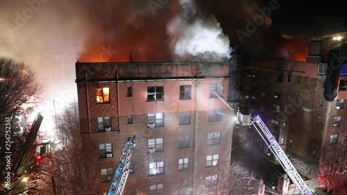 Firefighters Spray Water into a Burning Apartment Building from the Bucket of a Tower Ladder, Static Extra Wide Shot