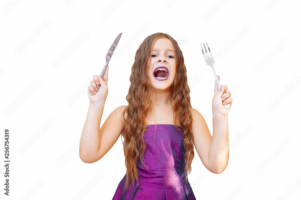 Beautiful little girl with long hair in evening dress, portrait emotionally posing with a knife and fork, isolated Beautiful little girl with long hair in evening dress, portrait emotionally posing with a knife and fork, isolated