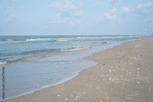 Tropical nature clean beach and white sand in summer with sun light blue sky and bokeh background.