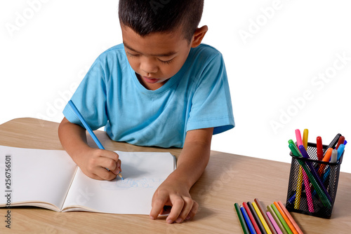 Cute cheerful child drawing using color pencil while sitting at table isolated on white background