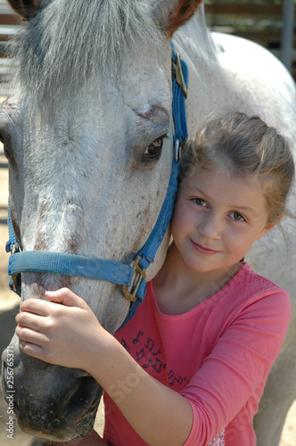 young girl smiling with a white horse