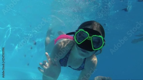 happy Girl Jump In Swimming Pool Dive And Looking At The Camera photo