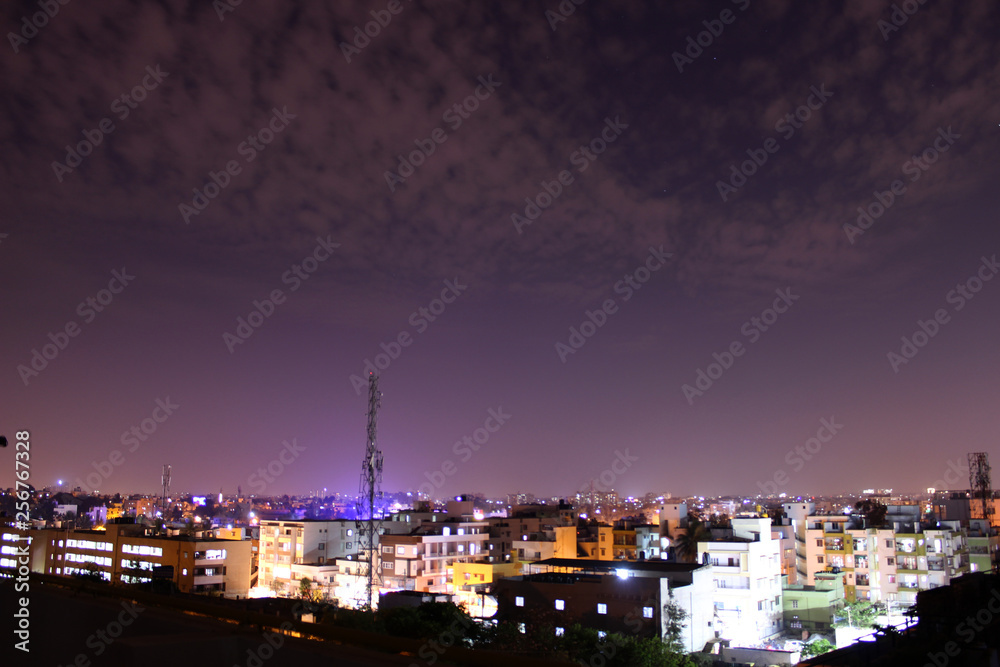 Evening cityscape with blue light haze and fast moving clouds