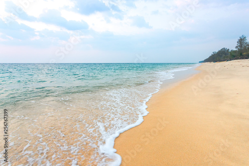 Clean sand on the beach have sea wave coming up diagonal to island  with soft blue sky with cloudy