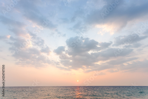 wide soft blue sky have some cloud with orange light color from sunset then spread to the sea