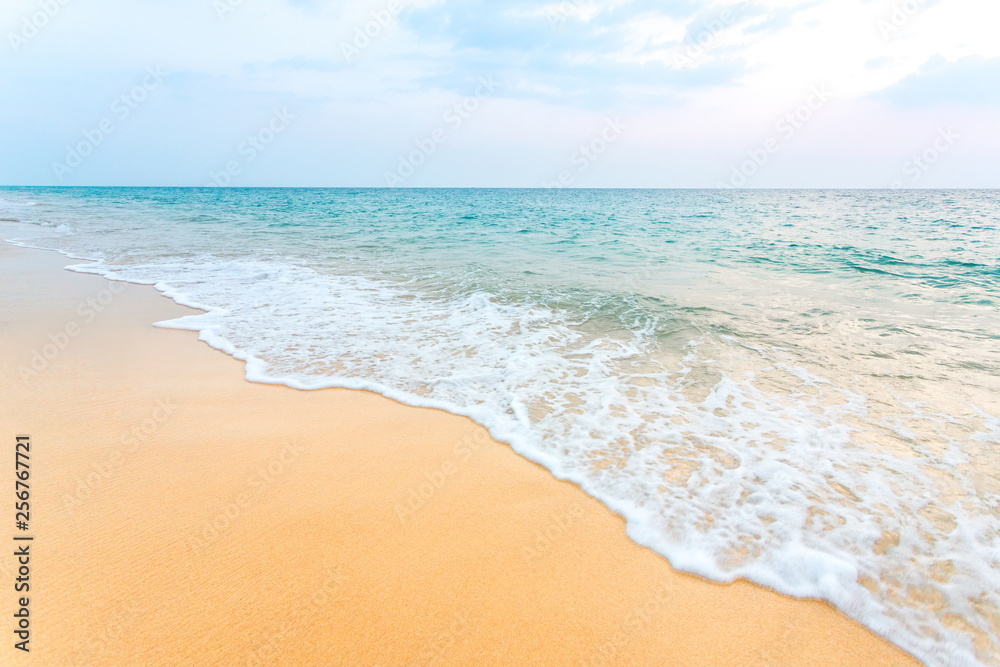 Clean sand on the beach have sea wave coming up diagonal, with soft blue sky with cloudy