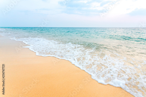 Clean sand on the beach have sea wave coming up diagonal, with soft blue sky with cloudy