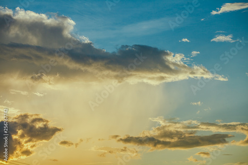 sunshine with pouring rain and dark clouds  on over blue sly