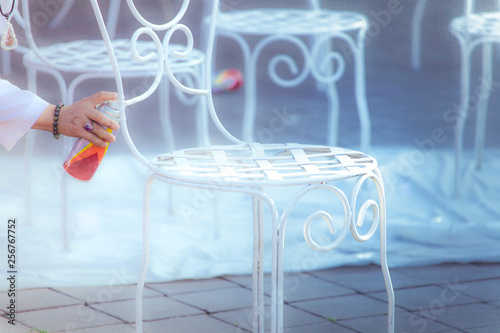 Men is spraying to white chair