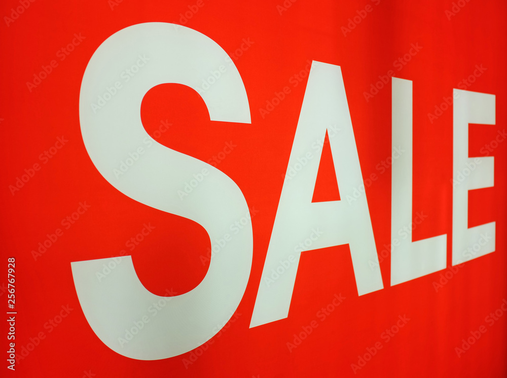 White Sale sign on red background in the shop. White Sale sign on red background in the shop.