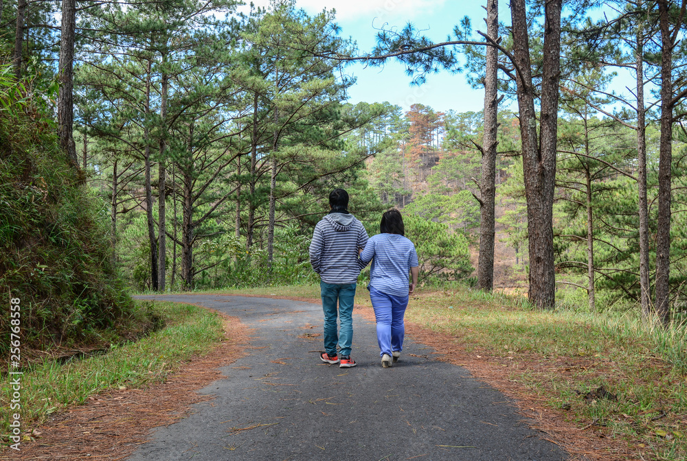 Happy couple walking in the pine forest Happy couple walking in the pine forest