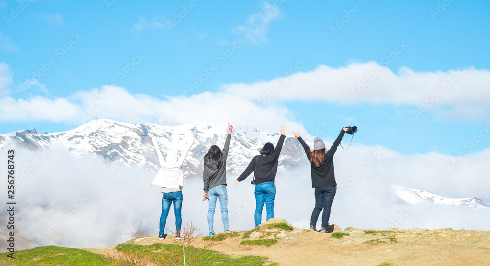 Group of women tourist enjoying their holiday road trip on the ridge of the mountain nearly Crown Range Road, the highest paved highway in Cardrona valley, Otago region of New Zealand. - obrazy, fototapety, plakaty 
