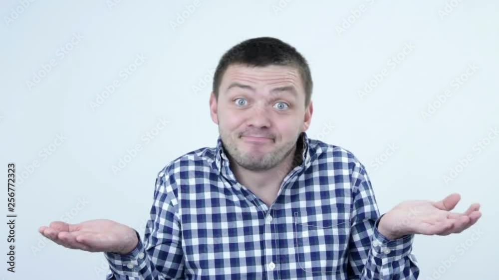 The man throws up his hands in a plaid shirt and squirms his face The man throws up his hands in a plaid shirt and squirms his face