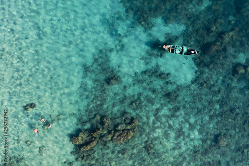 View from above, stunning aerial view of a long-tail boat and tourists who do snorkelling in a beautiful and turquoise sea, Phi Phi Island, Maya Bay, Thailand.