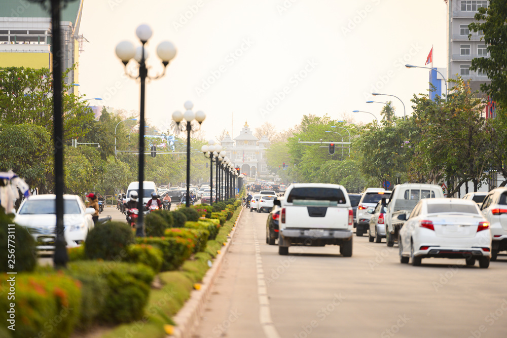 Local traffic during sunset on the busy streets of Vientiane, Laos. Vientiane is the capital and largest city of Laos, on the banks of the Mekong River near the border with Thailand.