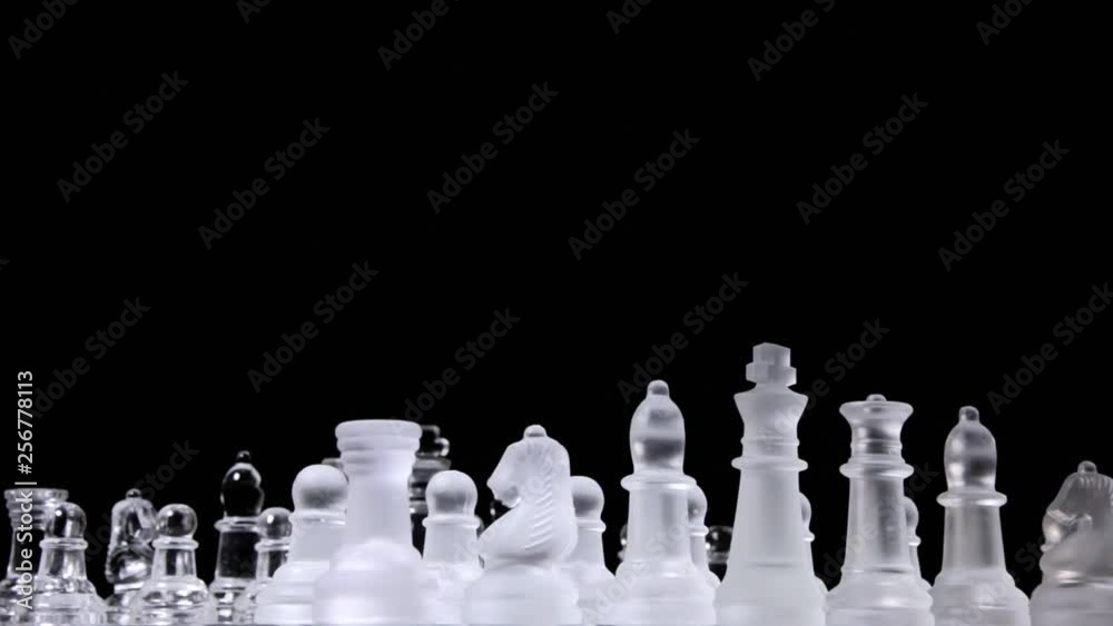 A glorious chessboard with two different full sets of chess pieces made of glass, rotating into a starting position, ready for the match. A glorious chessboard with two different full sets of chess pieces made of glass, rotating into a starting position, ready for the match.