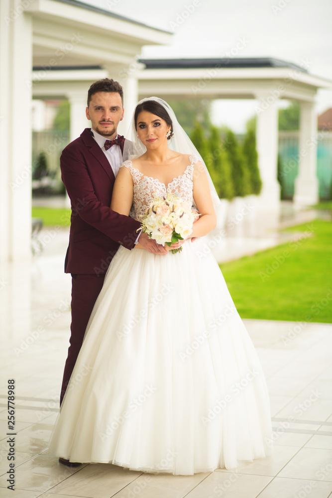 Happy wedding couple posing near garden