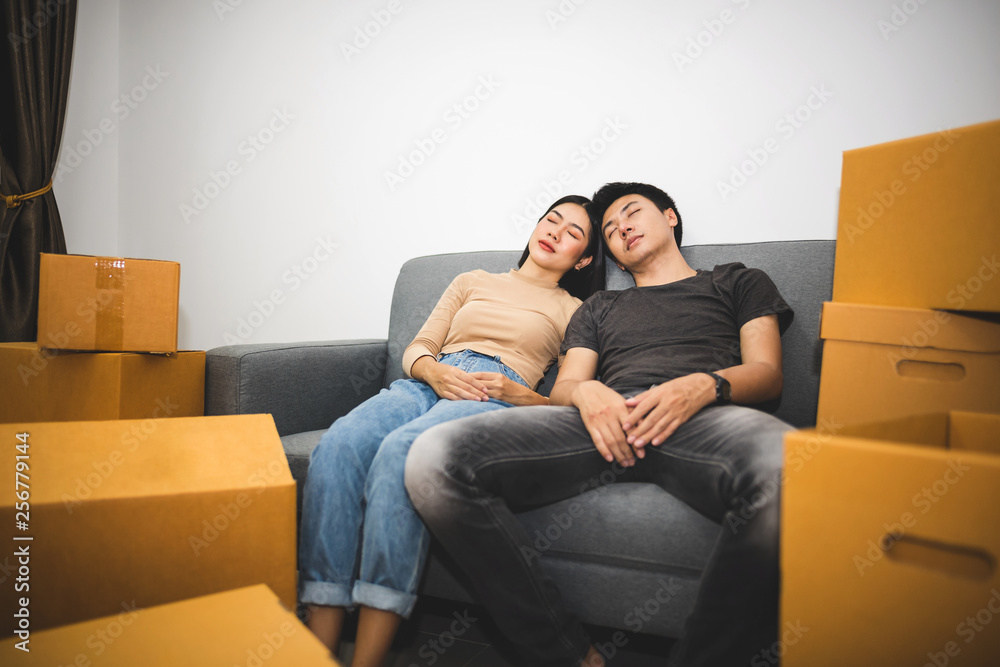 Young couples are sleeping on the sofa. After being tired of moving into a new home. Young couples are sleeping on the sofa. After being tired of moving into a new home.