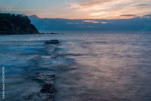 Long Exposure of a Sunset on the Southern Mediterranean Sea in Italy with Ancient Roman Wall