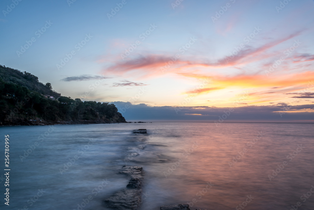 Long Exposure of a Sunset on the Southern Mediterranean Sea in Italy with Ancient Roman Wall Long Exposure of a Sunset on the Southern Mediterranean Sea in Italy with Ancient Roman Wall