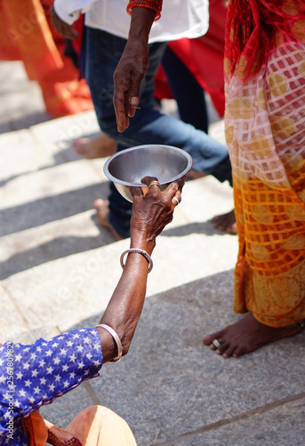 Indian devotee give money to poor woman seeking help or begging,near Hindu temple  during maha shiva ratri festival celebrations 