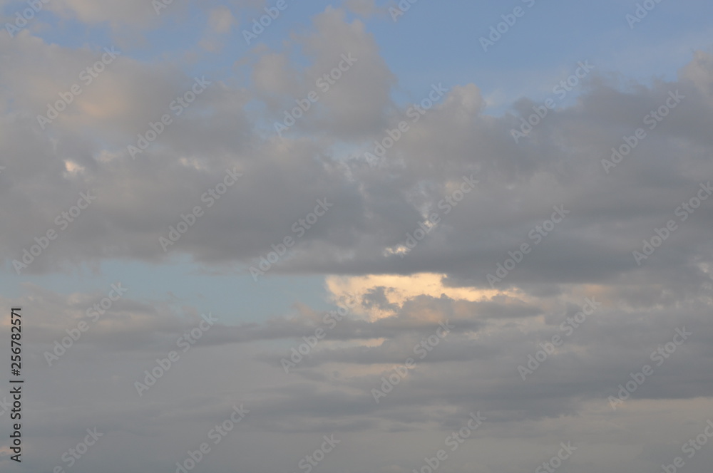 Blue sky with gray clouds obscuring the sun Blue sky with gray clouds obscuring the sun