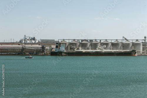 Odessa, Ukraine, South-March 20, 2019: Aerial view of panoramic seaport warehouse and container ship, crane vessel is working to deliver containers. South Sea Industrial Port, Port Factory