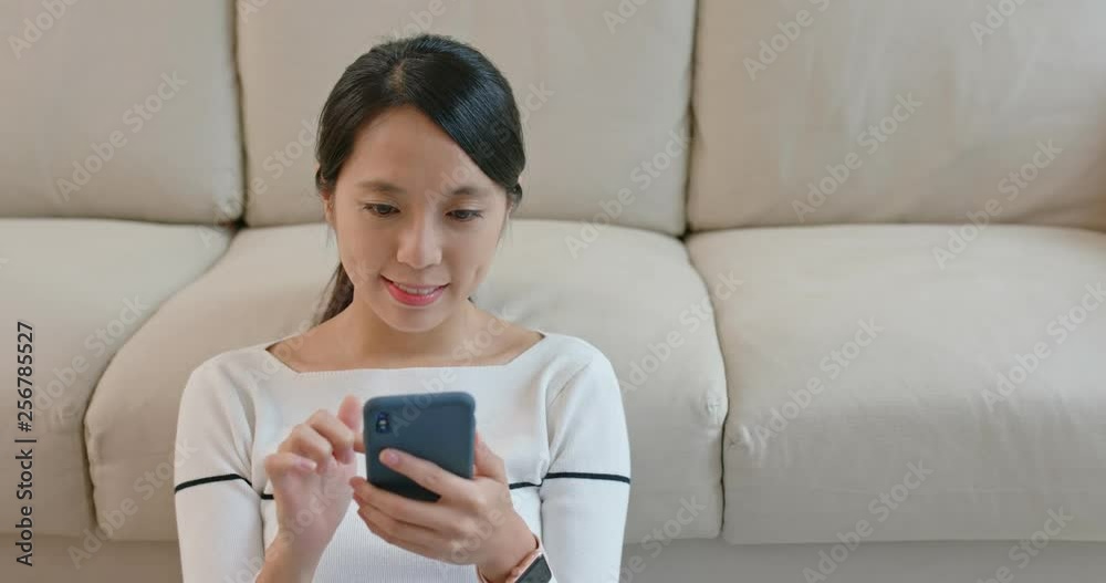 Woman send sms on cellphone at home Woman send sms on cellphone at home
