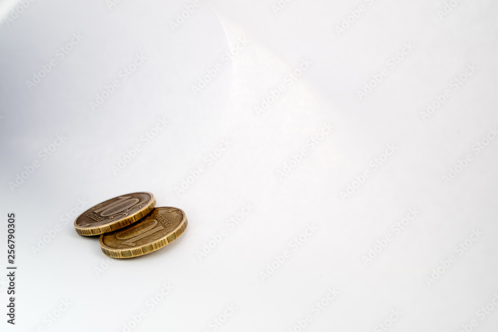 two copper coins lying on a sheet of white paper light shadow and light around the perimeter