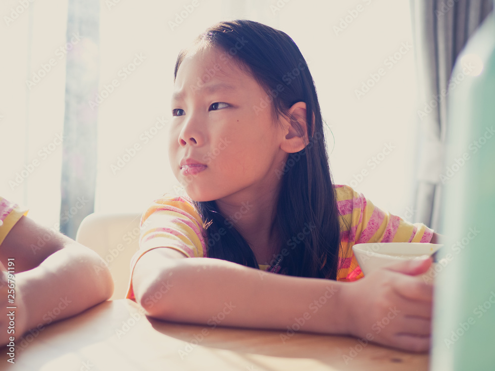 Cute Asian girl eats rice soup for breakfast Cute Asian girl eats rice soup for breakfast