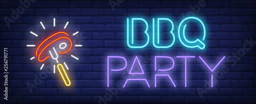 BBQ Party neon text with shining beef steak on fork photo