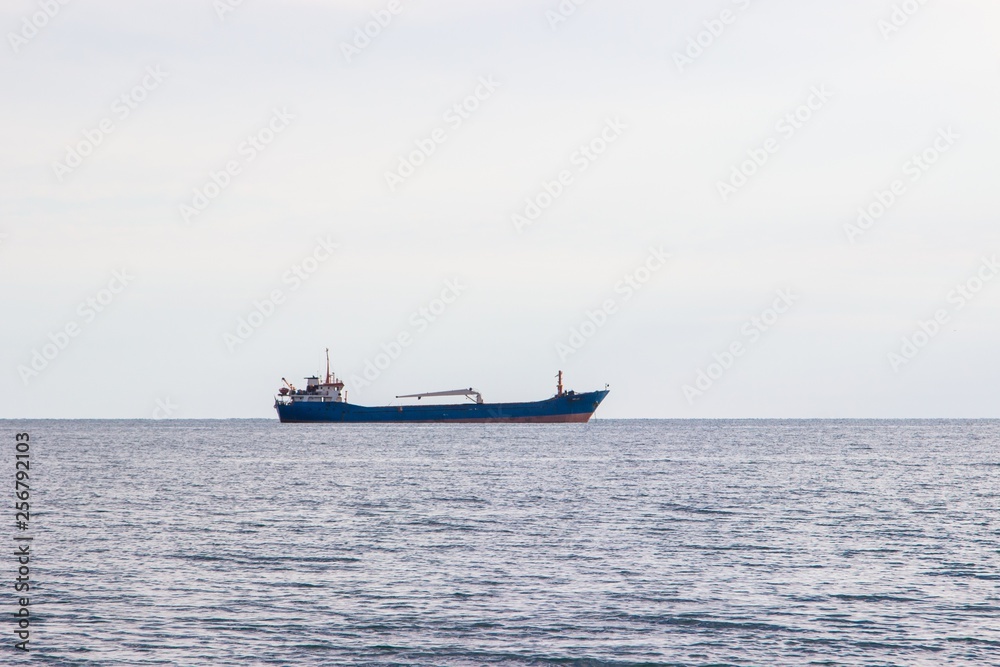 Tranquil seascape with ship at background