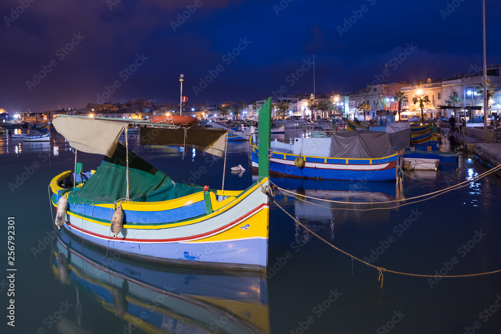 Traditional Maltese boats luzzu in Marsaxlokk at the night