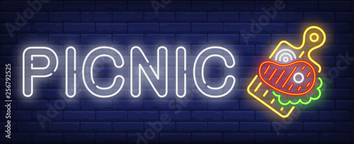Picnic neon text with beef steak on cutting board
