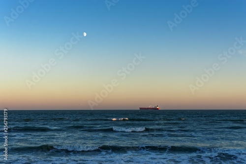Red Ship on the Horizon at Sunset