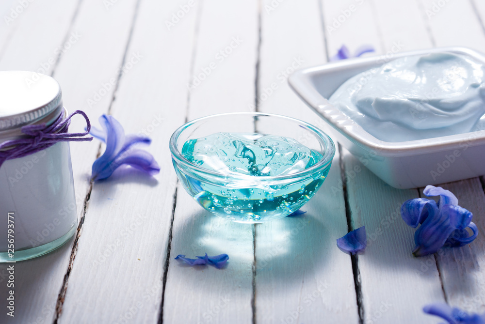 skin care product samples and purple hyacinth flowers on white wooden skin care product samples and purple hyacinth flowers on white wooden