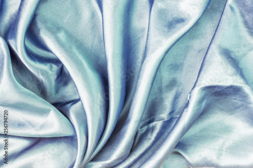 Light blue abstract background for layout. Beautiful silk folds. Photo close up.